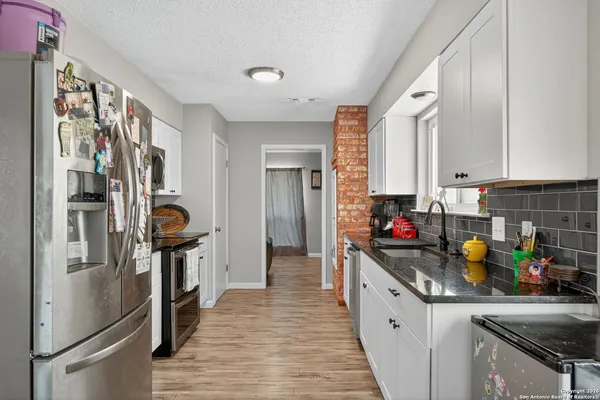 a kitchen with stainless steel appliances granite countertop a refrigerator and a sink