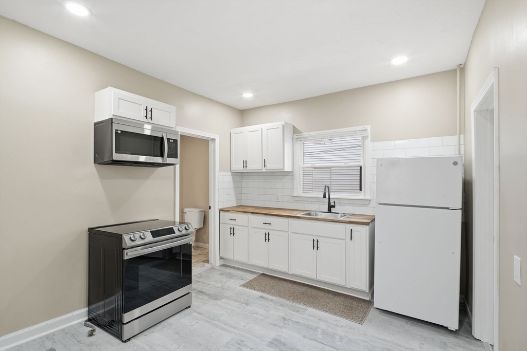 52 Osgood Street Springfield, MA 01107 - Photo 4 of 42 a kitchen with stainless steel appliances a stove sink and microwave