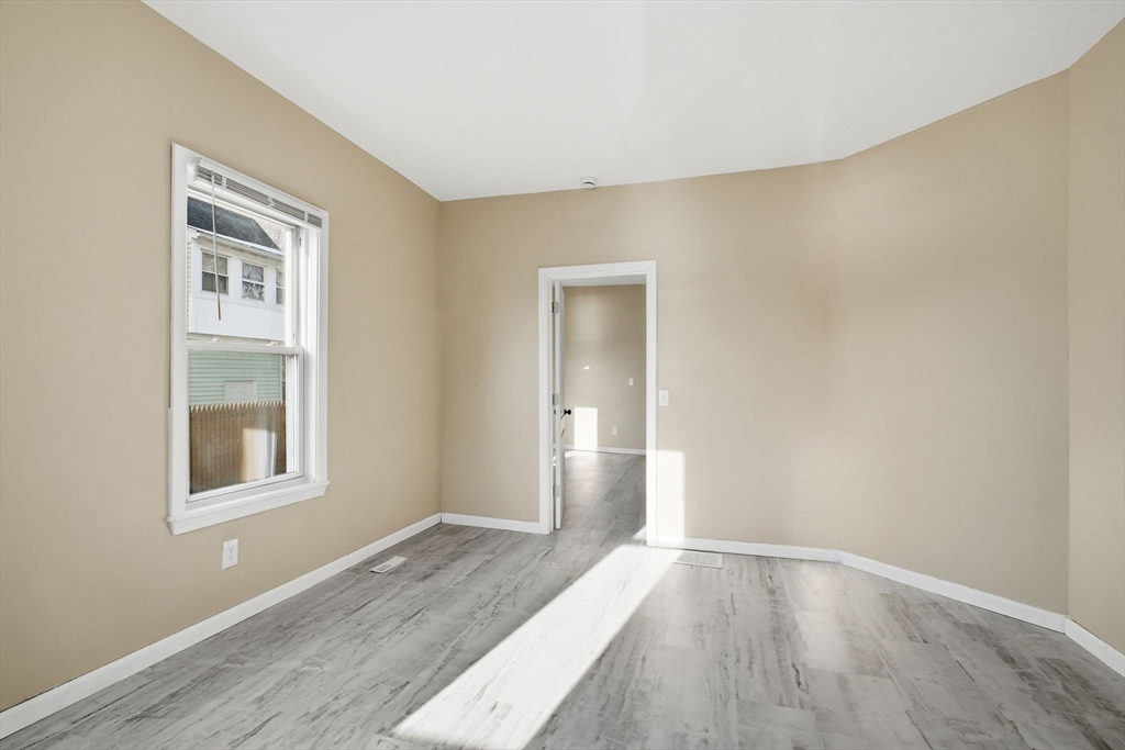 52 Osgood Street Springfield, MA 01107 - Photo 10 of 42 a view of an empty room with wooden floor and a window