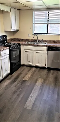a kitchen with stainless steel appliances sink a stove and cabinets