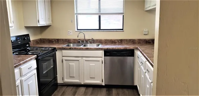 a kitchen with stainless steel appliances granite countertop a sink and a stove