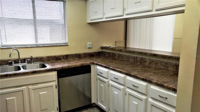 a kitchen with granite countertop a sink and cabinets