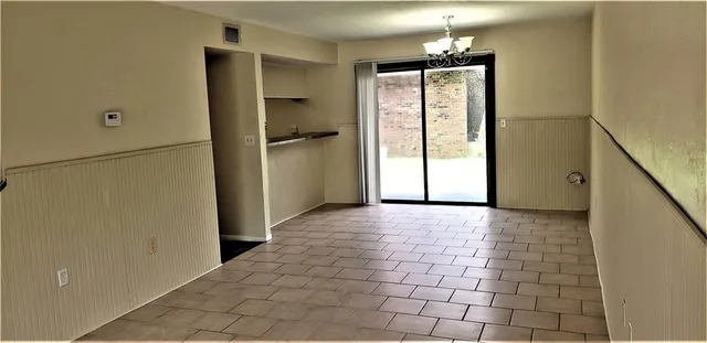 a view of empty room with window and refrigerator