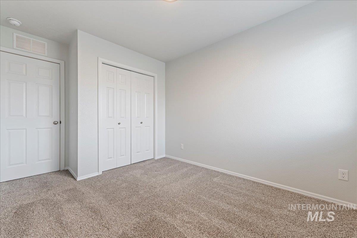 961 West Apple Pine Street Meridian, ID 83646 - Photo 20 of 30 Unfurnished bedroom featuring carpet flooring and a closet