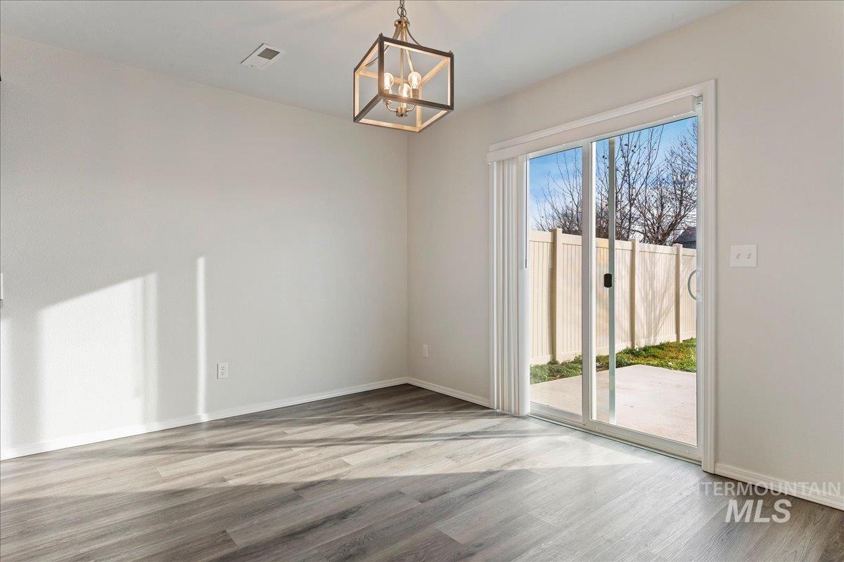 961 West Apple Pine Street Meridian, ID 83646 - Photo 8 of 30 Unfurnished dining area with a chandelier and light wood-type flooring
