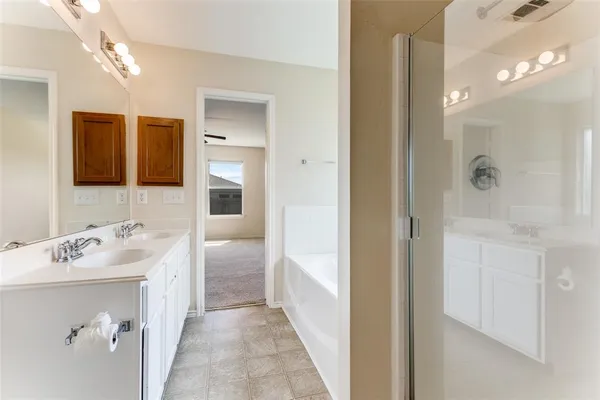 a en suite bathroom with a sink a mirror and shower