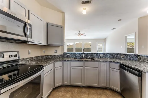 a kitchen with stainless steel appliances granite countertop a sink stove and cabinets