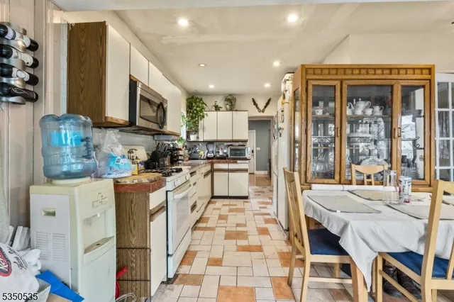 a kitchen with stainless steel appliances granite countertop a stove a sink a microwave a refrigerator and cabinets