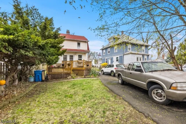 a front view of a house with a garden and parking space
