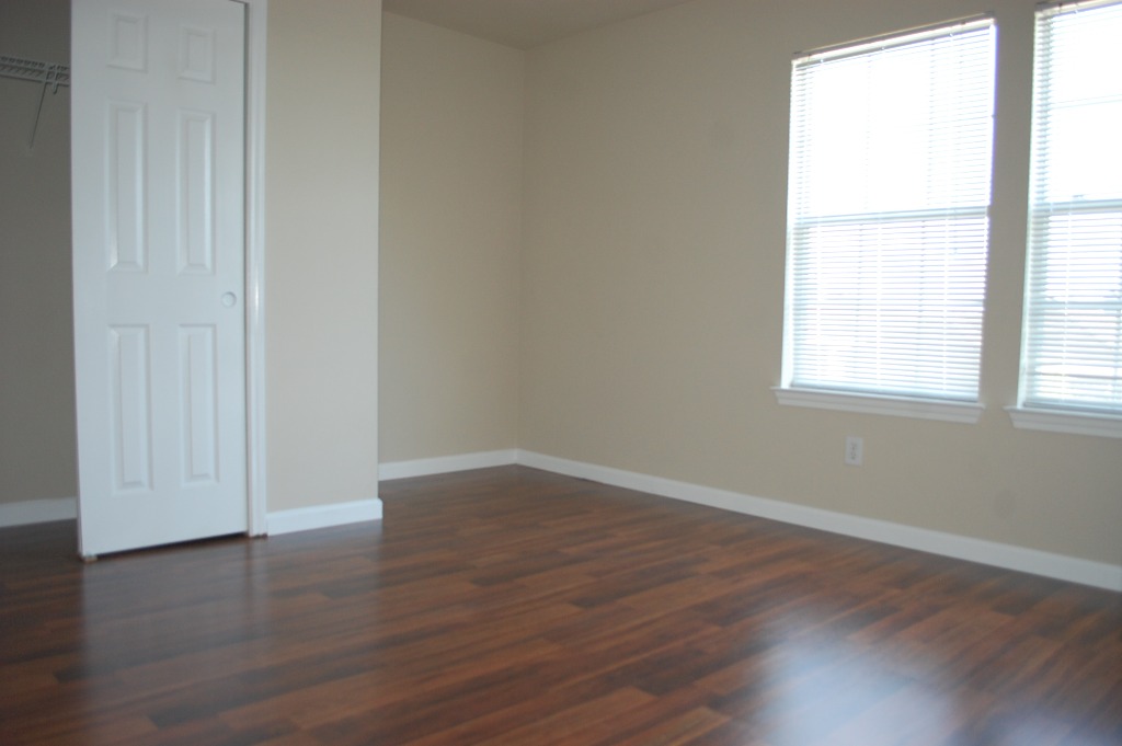 11300 Dimmit Street Manor, TX 78653 - Photo 16 of 23 Rich wood flooring and generous windows define this well-lit room, ready for your personal touch.