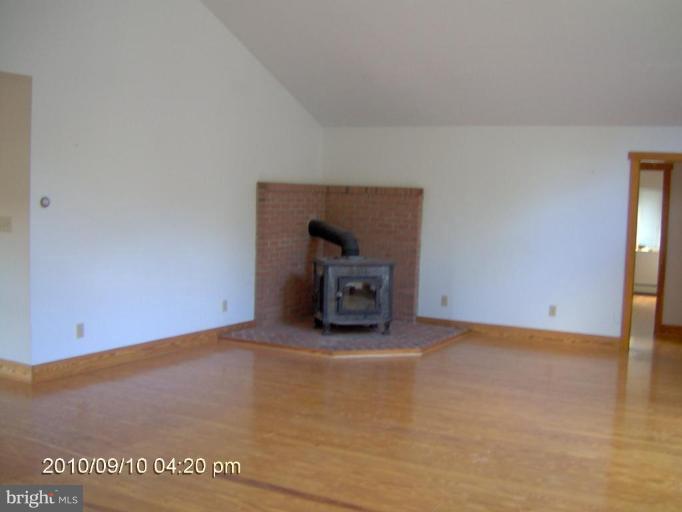 325 Silver Road Berkeley Springs, WV 25411 - Photo 11 of 21 a view of an empty room with a fireplace and a window