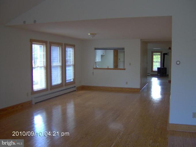 325 Silver Road Berkeley Springs, WV 25411 - Photo 12 of 21 an empty room with wooden floor and windows