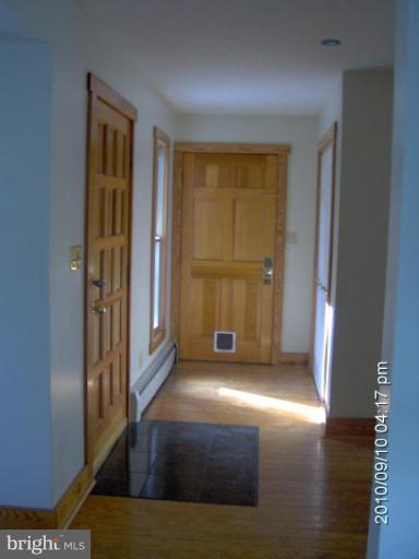 325 Silver Road Berkeley Springs, WV 25411 - Photo 15 of 21 a view of an empty room with wooden floor and a window