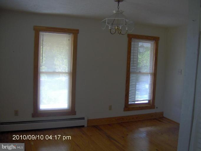 325 Silver Road Berkeley Springs, WV 25411 - Photo 18 of 21 an empty room with wooden floor windows and entrance