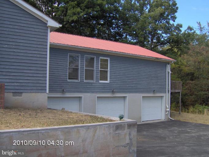 325 Silver Road Berkeley Springs, WV 25411 - Photo 4 of 21 a front view of a house with garage