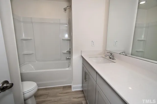 a white toilet sitting next to a bath tub