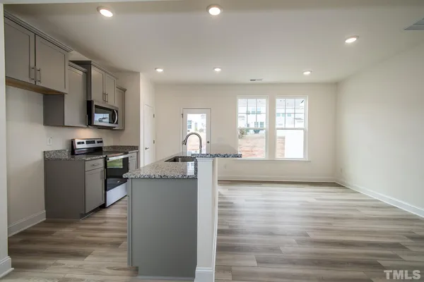 a kitchen with a refrigerator and a stove top oven