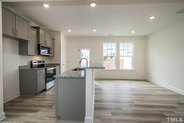 a kitchen with a refrigerator and a stove top oven
