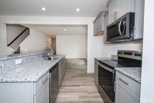 a kitchen with stainless steel appliances granite countertop a sink and a stove