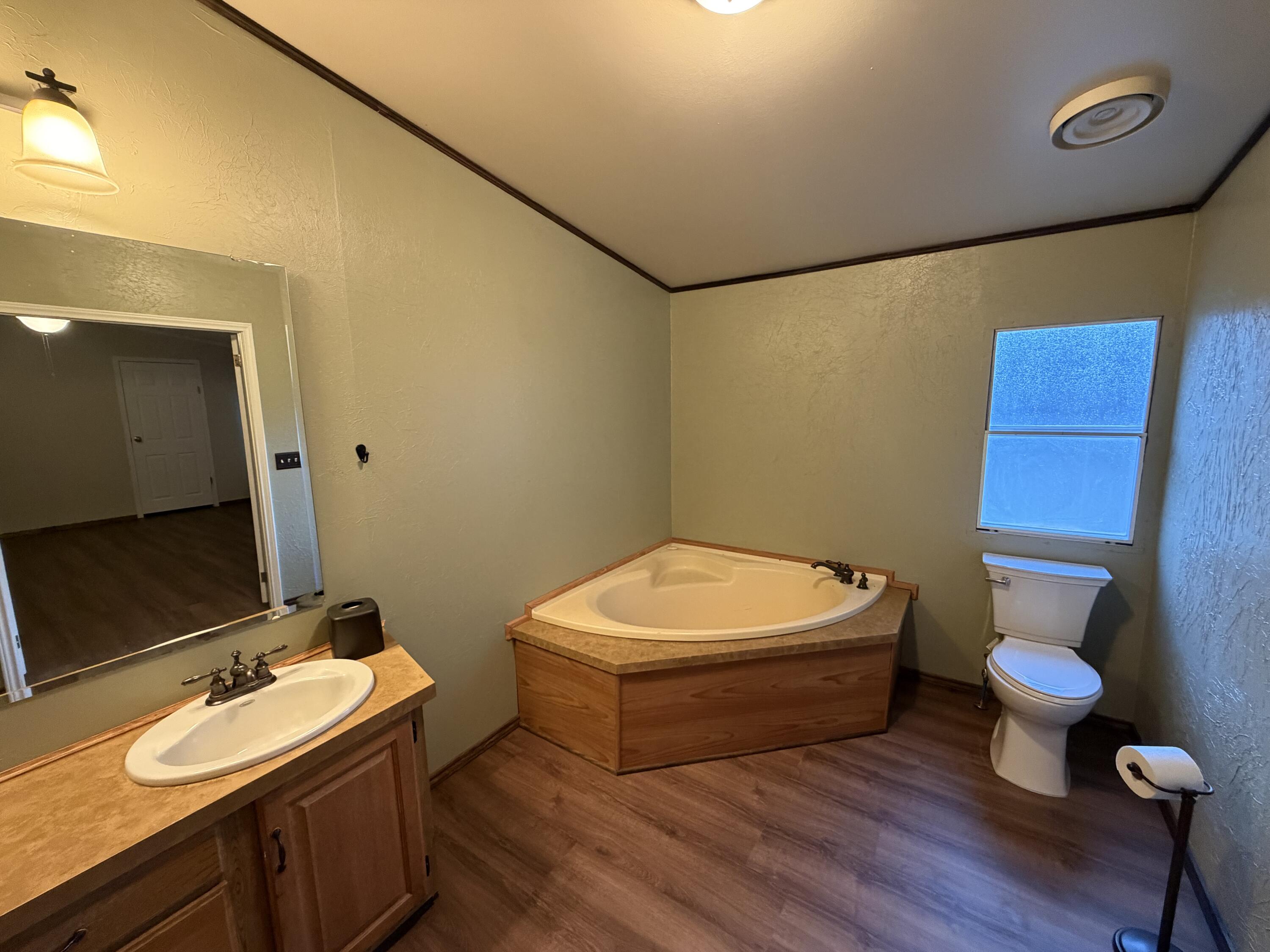 11120 Gentry Lane Slaton, TX 79364 - Photo 14 of 17 a bathroom with a sink mirror vanity and toilet
