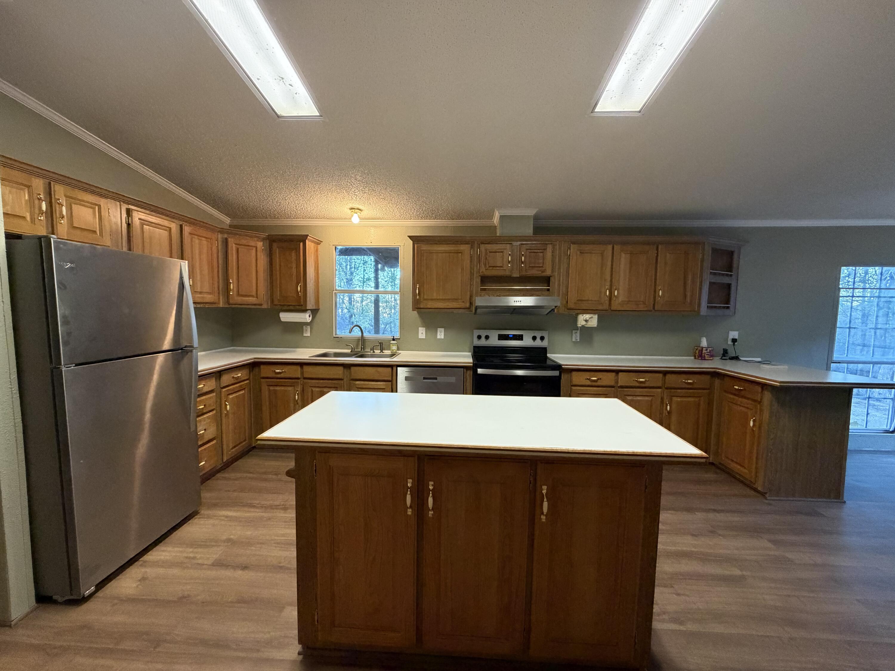 11120 Gentry Lane Slaton, TX 79364 - Photo 4 of 17 a kitchen with kitchen island a counter top space cabinets and stainless steel appliances