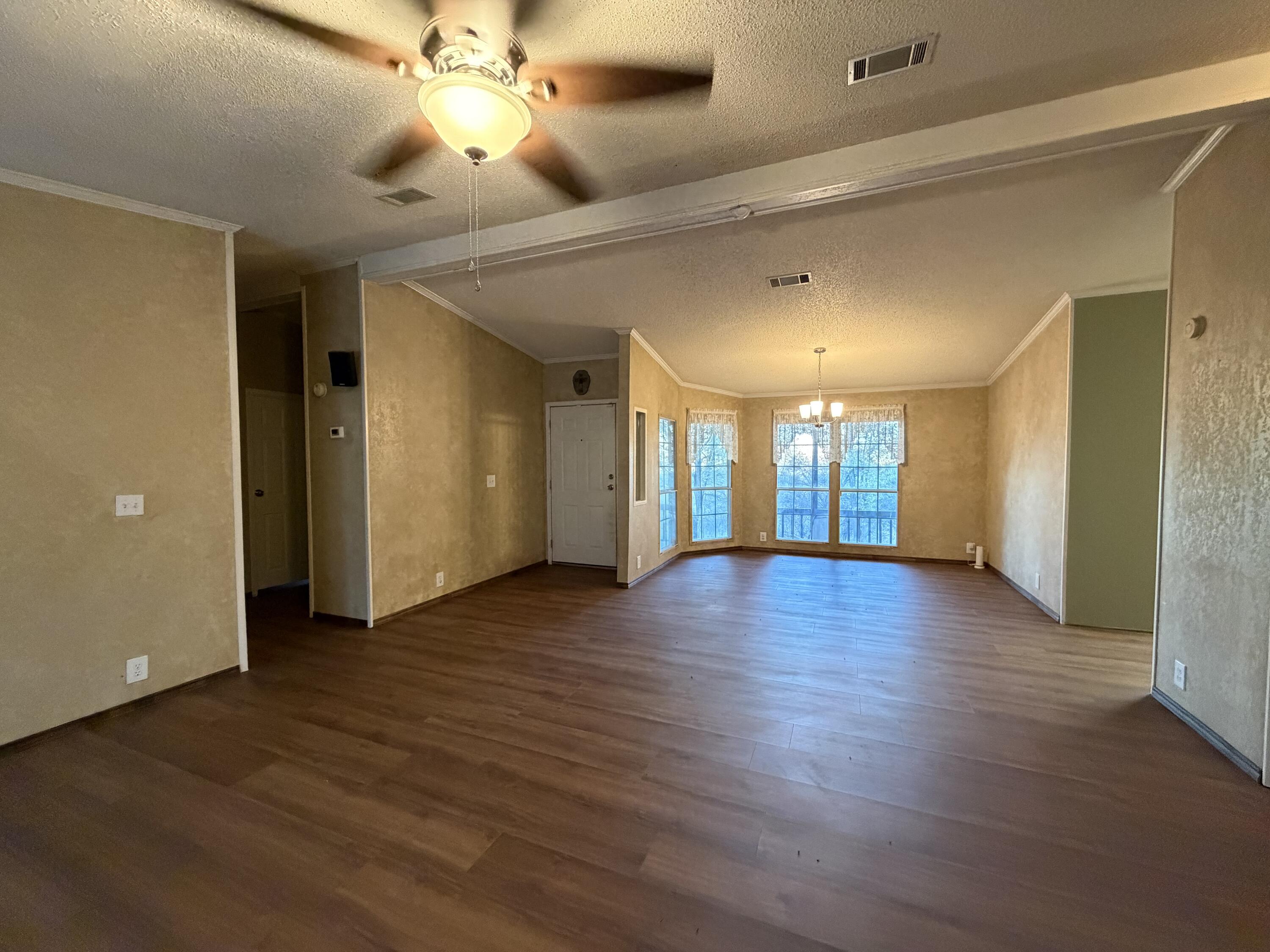 11120 Gentry Lane Slaton, TX 79364 - Photo 8 of 17 a view of an empty room with window and wooden floor