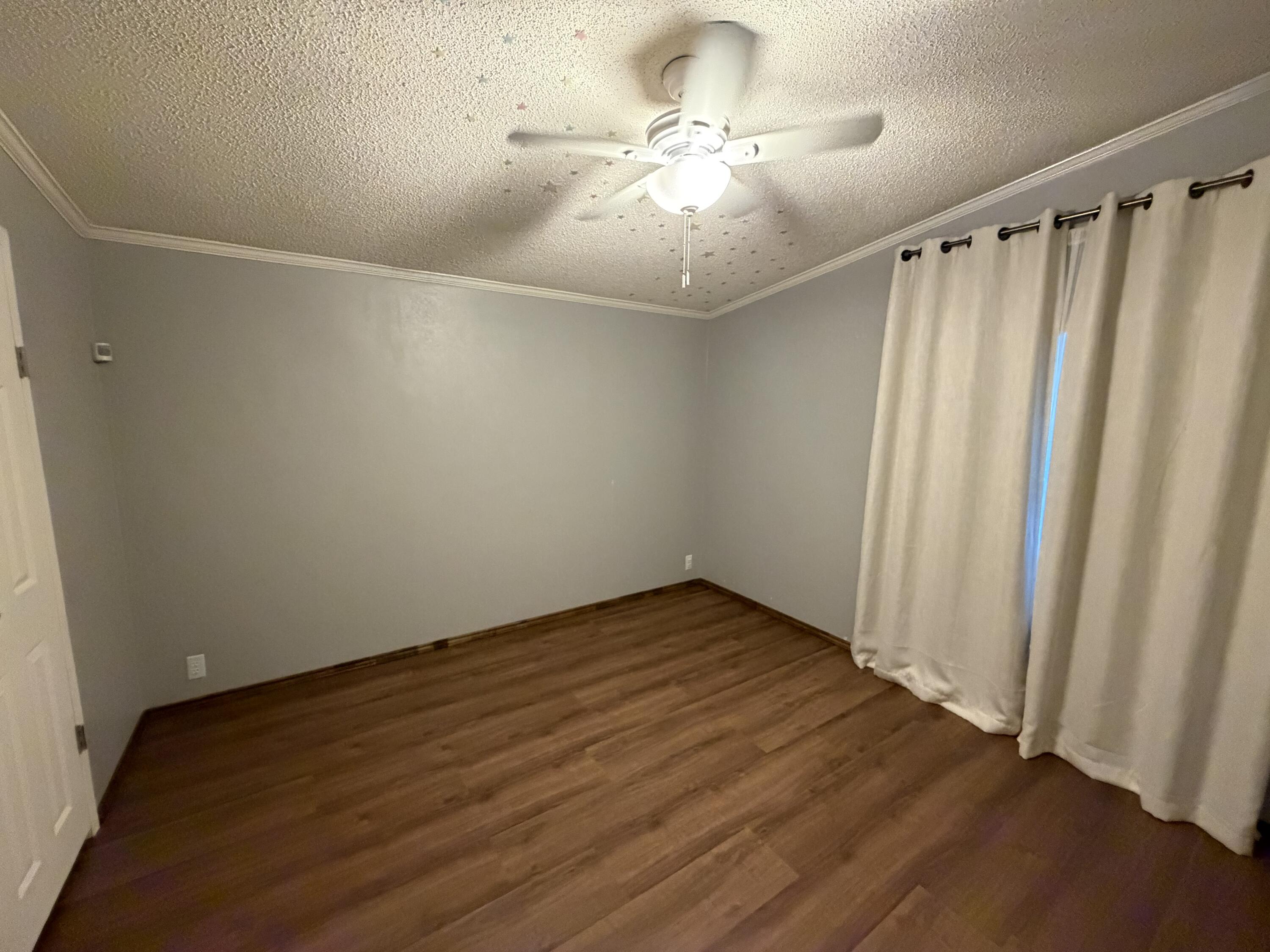 11120 Gentry Lane Slaton, TX 79364 - Photo 9 of 17 a view of an empty room with wooden floor