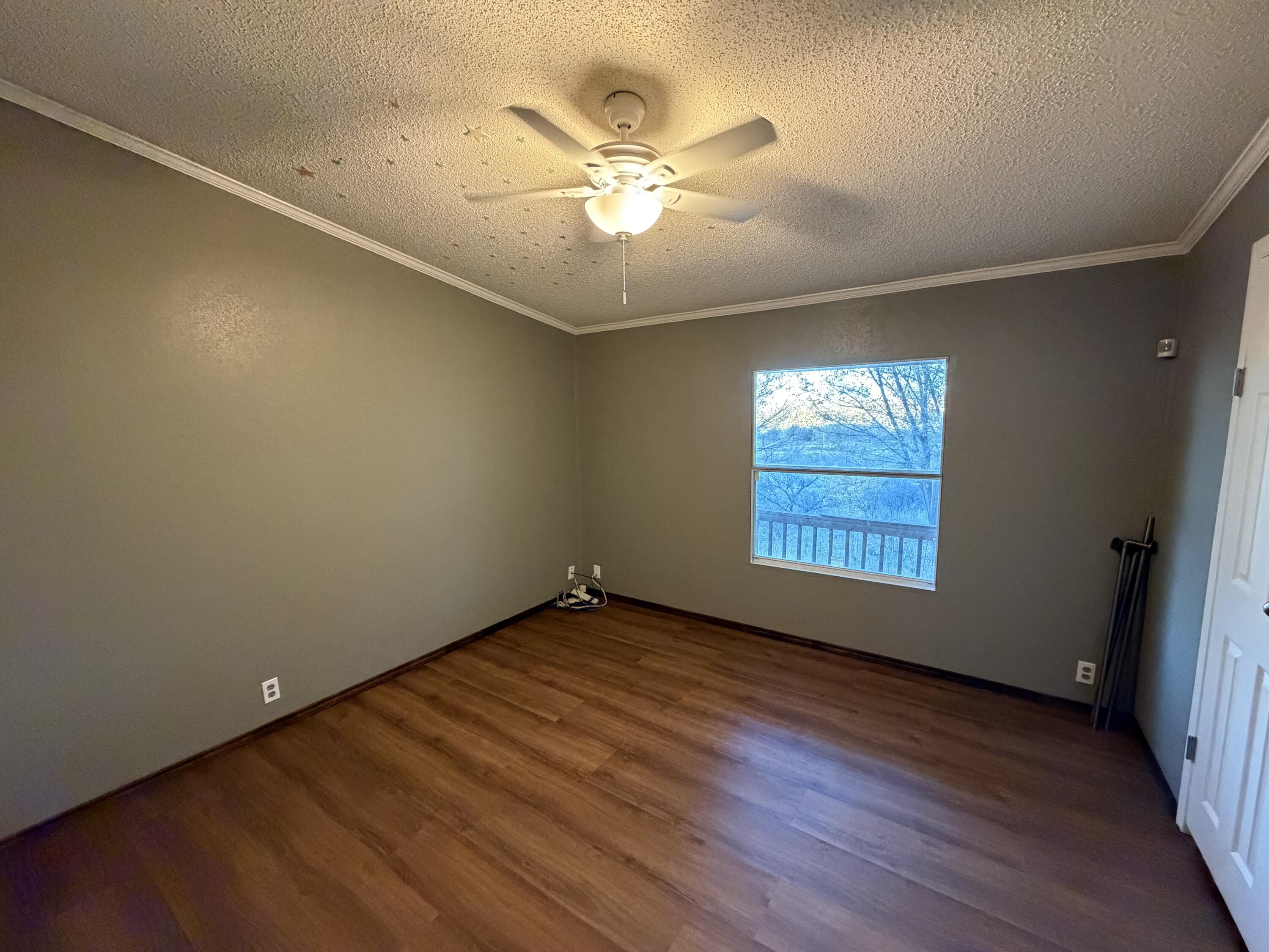 11120 Gentry Lane Slaton, TX 79364 - Photo 10 of 17 an empty room with wooden floor and windows