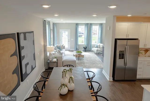 a very nice looking dining room with furniture and a refrigerator