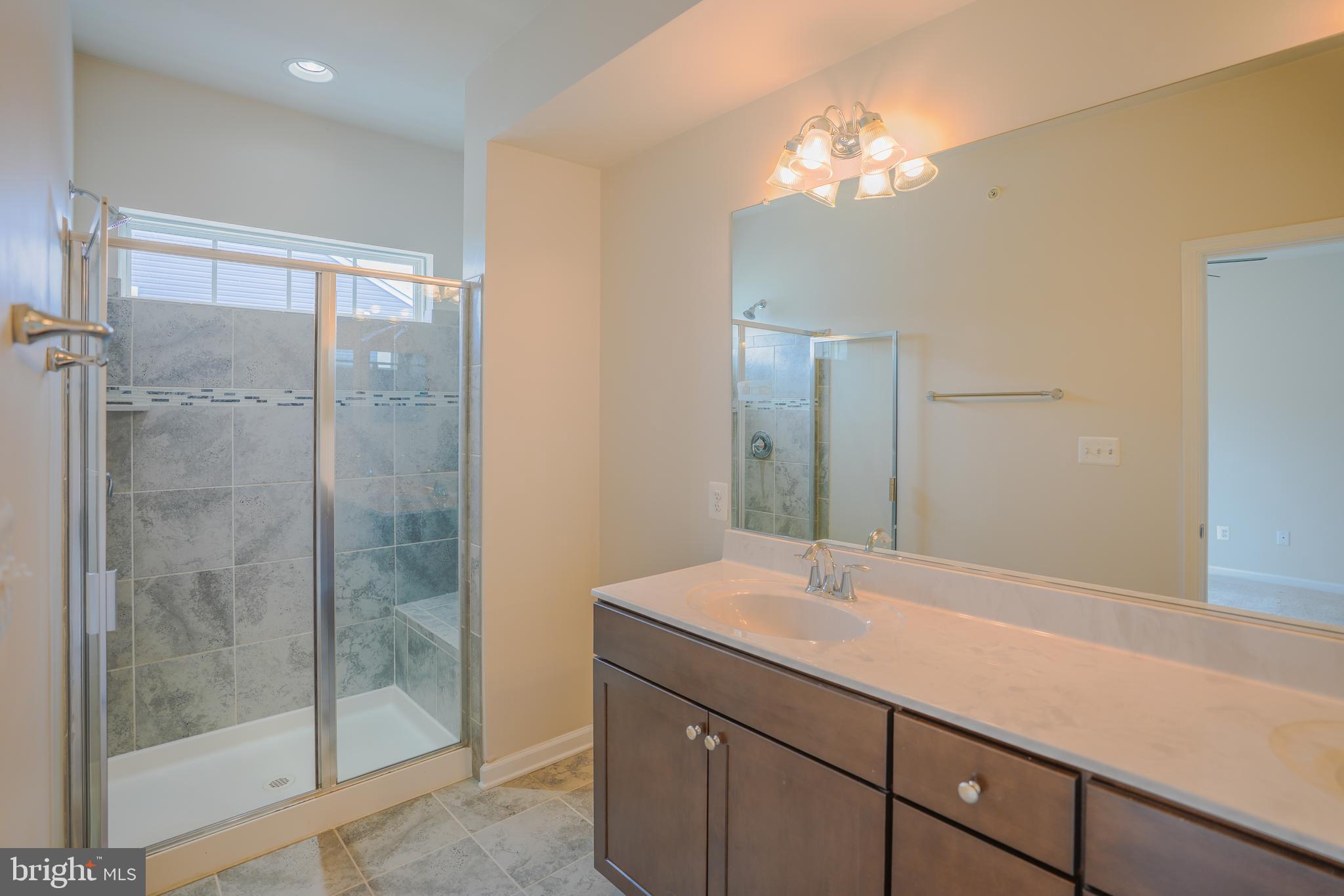 6150 Posey Street Frederick, MD 21703 - Photo 22 of 32 a bathroom with a shower sink and mirror