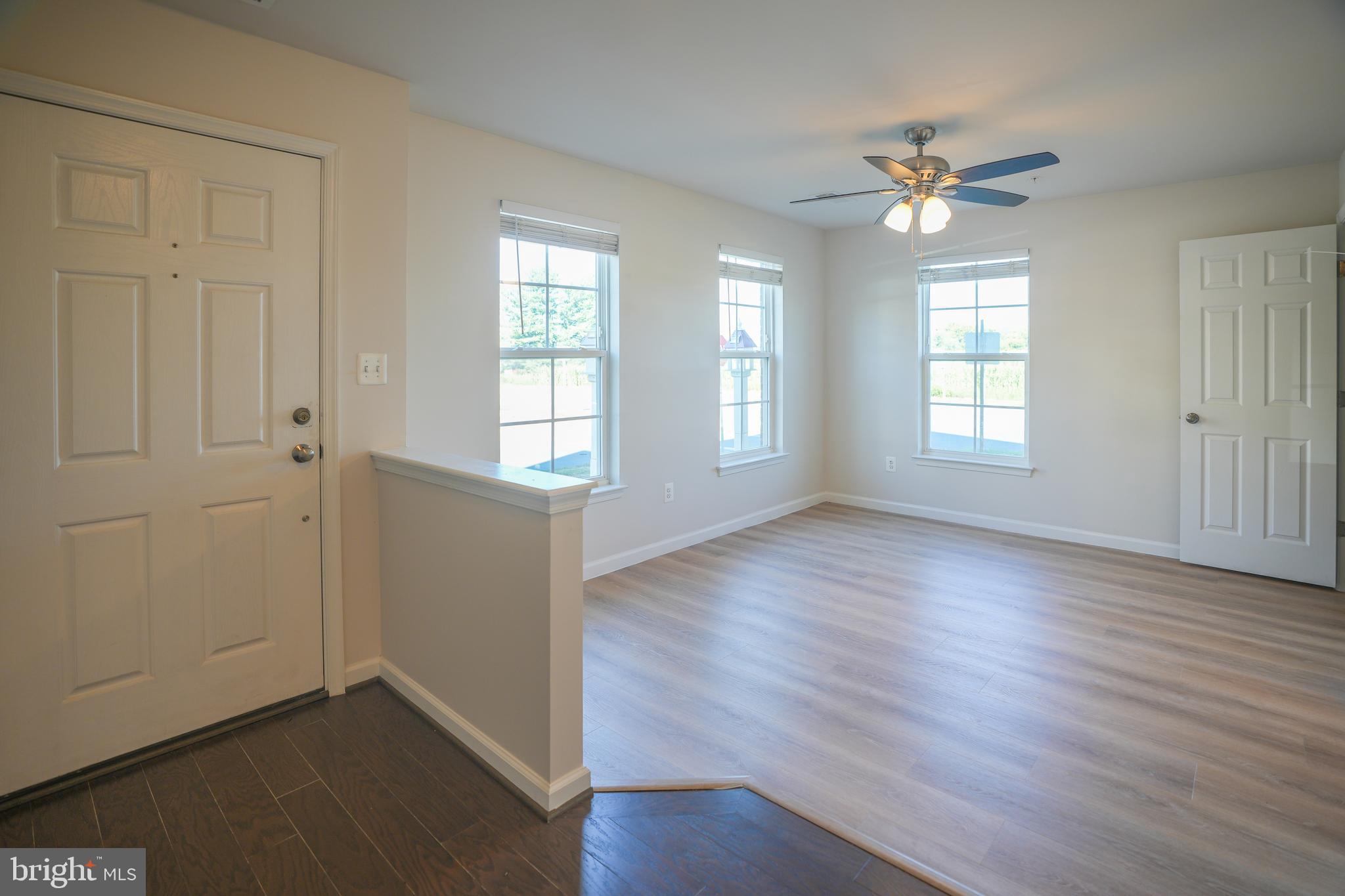 6150 Posey Street Frederick, MD 21703 - Photo 5 of 32 an empty room with wooden floor chandelier fan and windows