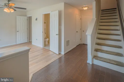 a view of a hallway with wooden floor and staircase