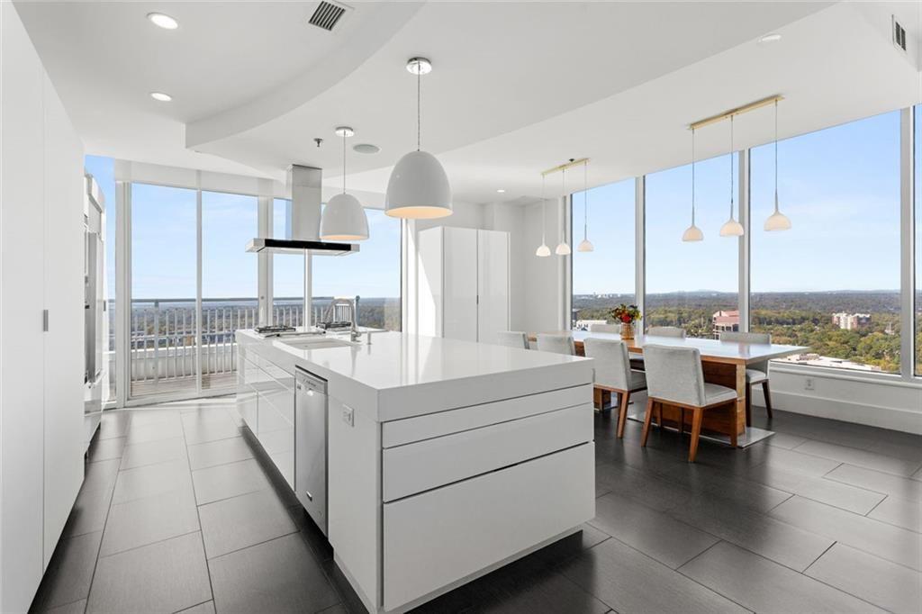 a large white kitchen with a large window and stainless steel appliances
