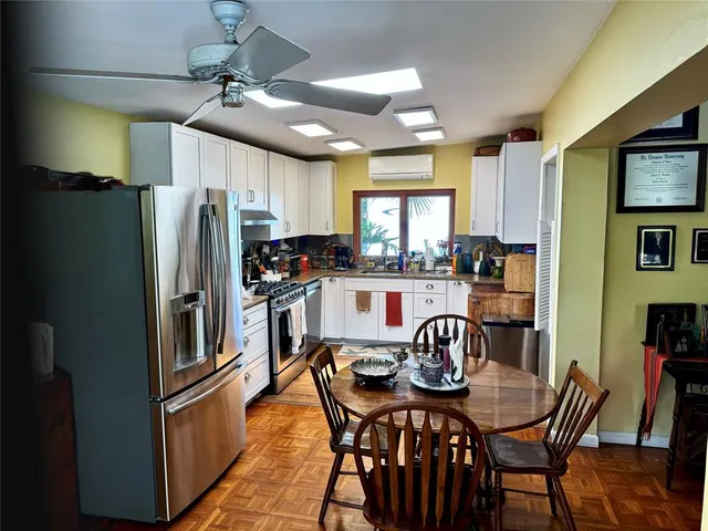 a kitchen with stainless steel appliances a table chairs and a refrigerator