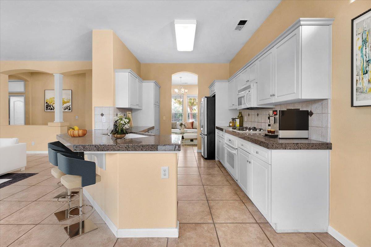 849 Megan Avenue Clovis, CA 93611 - Photo 48 of 53 a large kitchen with kitchen island granite countertop a large counter top and stainless steel appliances