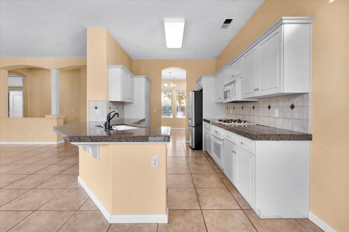 849 Megan Avenue Clovis, CA 93611 - Photo 8 of 53 a large kitchen with stainless steel appliances kitchen island granite countertop a sink and cabinets