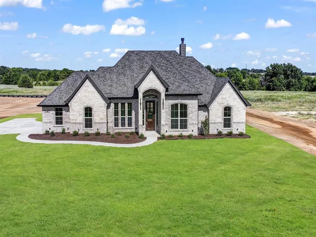 a view of a house with backyard and sitting area
