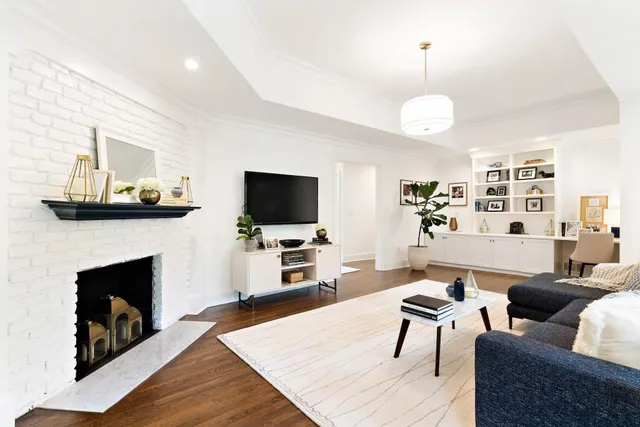 a living room with furniture a flat screen tv and a fireplace