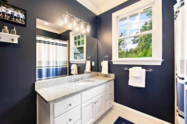 a en suite bathroom with a granite countertop sink and a mirror