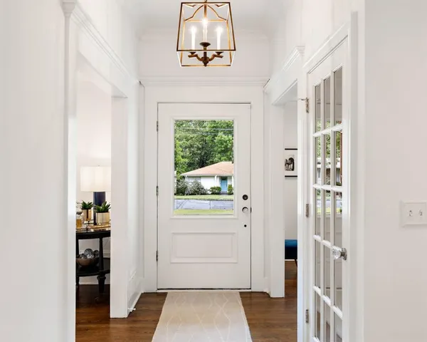 a view of a hallway with wooden floor and windows