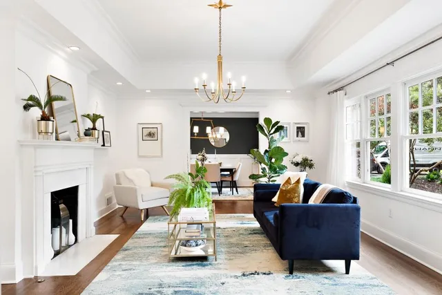 a living room with furniture a fireplace and a chandelier
