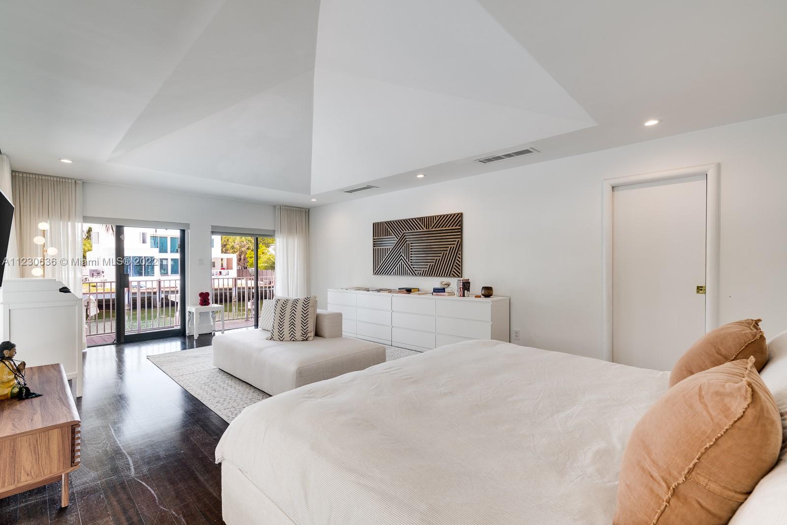 1922 Northeast 119th Road North Miami, FL 33181 - Photo 18 of 42 a bedroom with a balcony a bed and a flat screen tv