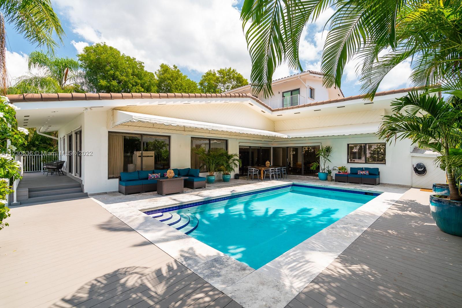 1922 Northeast 119th Road North Miami, FL 33181 - Photo 27 of 42 a view of a house with swimming pool and a chairs in patio