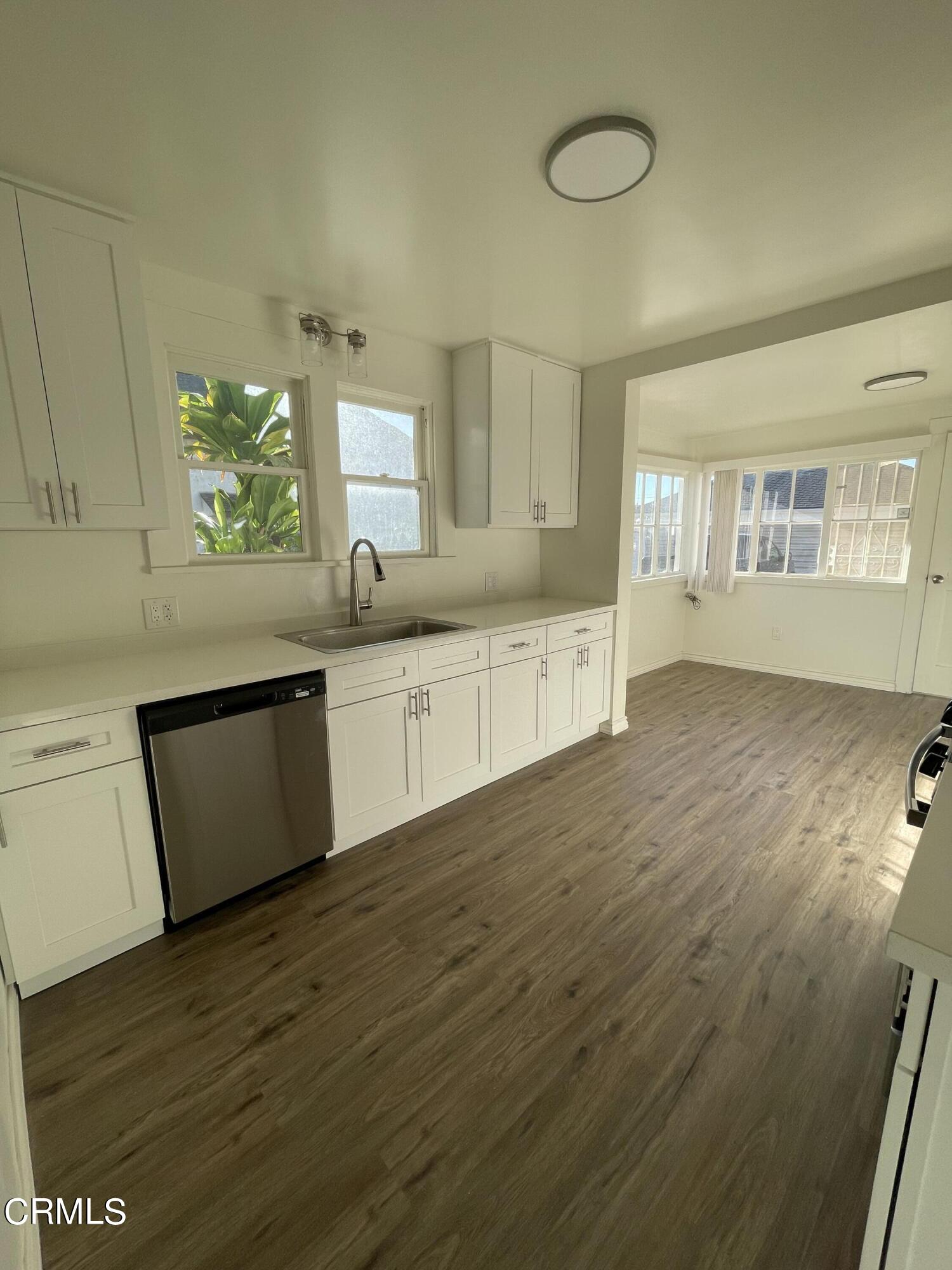 218 Wolff Street Oxnard, CA 93033 - Photo 3 of 12 a large kitchen with stainless steel appliances granite countertop a sink and a wooden floor