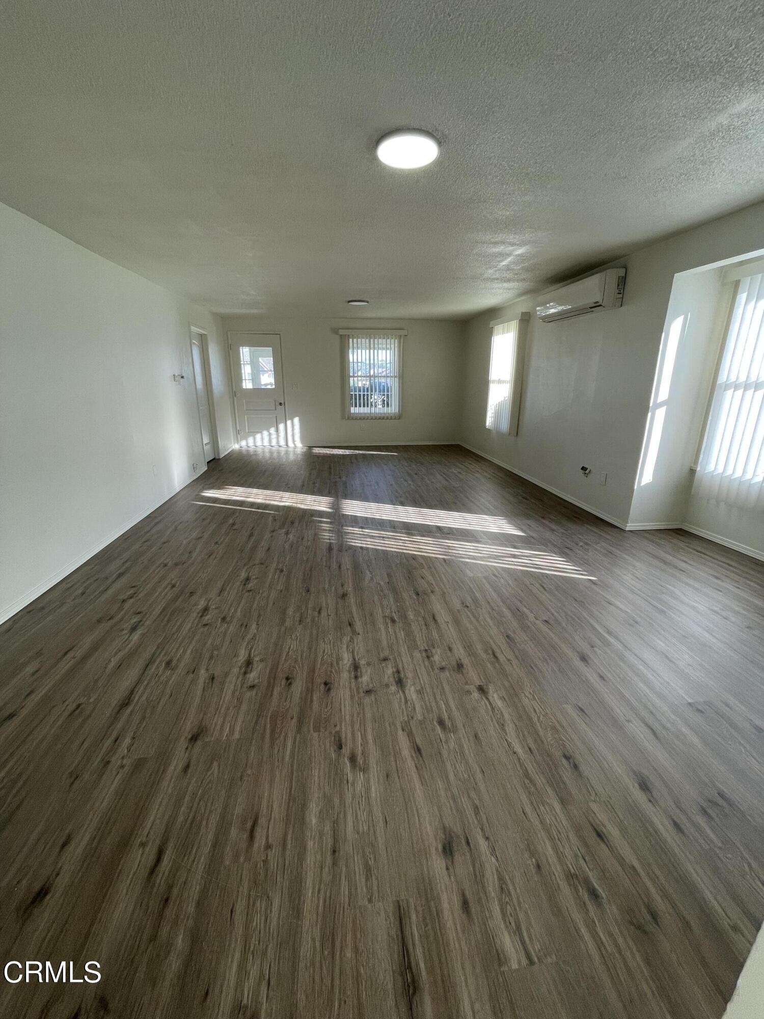 218 Wolff Street Oxnard, CA 93033 - Photo 5 of 12 wooden floor in an empty room with a window