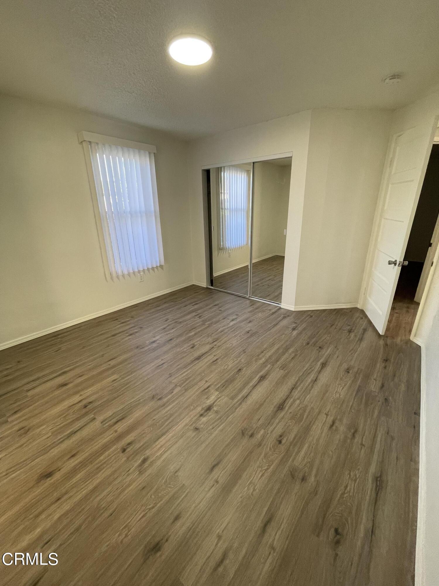 218 Wolff Street Oxnard, CA 93033 - Photo 9 of 12 wooden floor in an empty room with a window