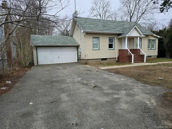 a view of a house with a yard and large tree