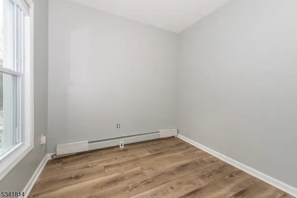 a view of a room with wooden floor and window
