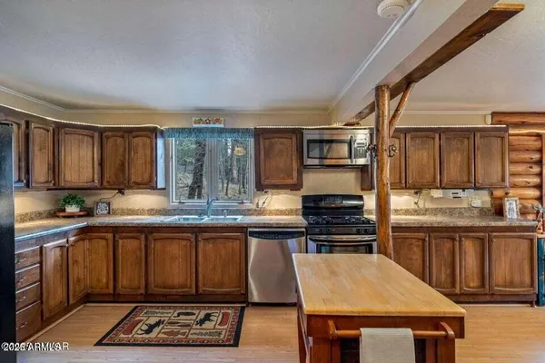 a kitchen with stainless steel appliances granite countertop a stove a sink dishwasher and cabinets with wooden floor