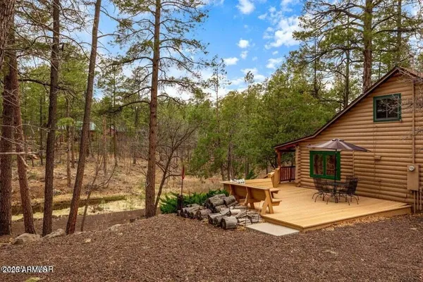 a view of a backyard with sitting area and tree